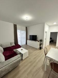 ein Wohnzimmer mit Sofa und Fernseher in der Unterkunft Noir Suite in Şelimbăr