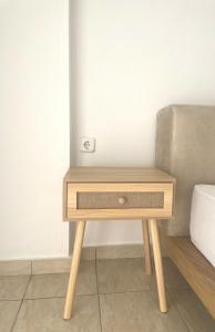 a small wooden table in a room with a bed at Pnoe Home in Kavála