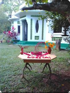 ein Tisch mit Blumen darauf vor einem Haus in der Unterkunft Brenley B Bungalow in Talalla