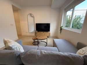 a living room with a couch and a tv at NEW - Old Town Modern Apartment Close to Beach in Estepona
