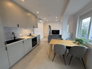 a kitchen with white cabinets and a wooden table at NEW - Old Town Modern Apartment Close to Beach in Estepona