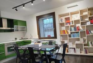 una cucina con tavolo, sedie e librerie di Apollo Theater Palace Lecce Exclusive Terrace a Lecce