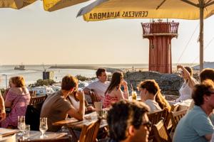 eine Gruppe von Menschen, die in einem Restaurant mit Strand sitzen in der Unterkunft Casa Alto Do Viso in Figueira da Foz