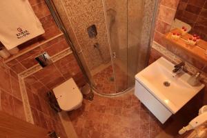 a bathroom with a shower and a toilet and a sink at Cunda Kivrak Hotel in Ayvalık +30 photos