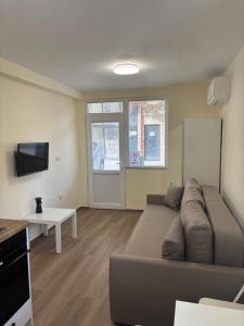 a living room with a couch and a table at Уют in Sandanski