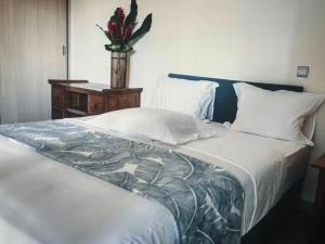 una camera da letto con un letto e un vaso di fiori su un tavolo di Stunning seasides retreat a Bora Bora