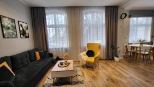 Studio - Apartamenty Parkowe في غنيزنو: غرفة معيشة بها أريكة وطاولة