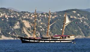 a large boat in the water with a city in the background at Villa Anna in Palinuro