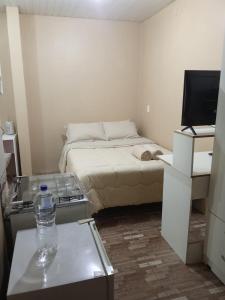 a small room with a bed and a television at Ada in Ciudad del Este