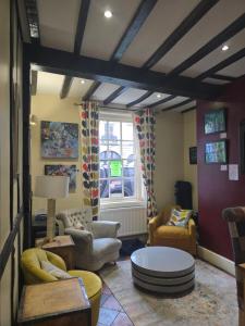 un salon avec des canapés, des chaises et une table dans l'établissement Twin room - The Unicorn Hotel, à Llanidloes