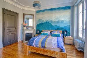 una camera da letto con un letto e un dipinto sul muro di Somptueuse villa au coeur du parc de la princesse a Le Vésinet