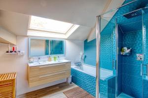 un bagno con vasca, lavandino e doccia di Somptueuse villa au coeur du parc de la princesse a Le Vésinet Altre 35 foto