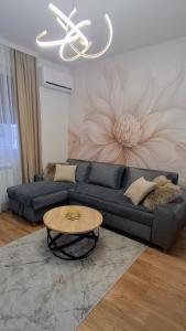 Una sala de estar con un sofá azul y una mesa. en Apartment Alina Istocno Sarajevo with private garage Lukavica, en Lukavica