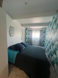 a bedroom with a bed with blue sheets and a window at Maison Marseille Jacuzzi, jardin, parking in Marseille