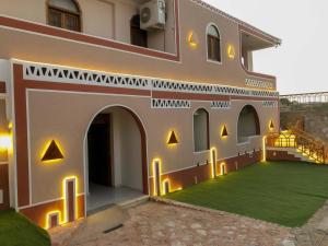 an external view of a building with a green lawn at Sharty Hotel in Abu Simbel +74 photos