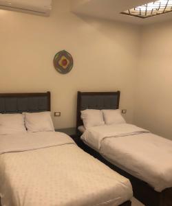 Dos camas una al lado de la otra en una habitación. en Sharty Hotel, en Abu Simbel