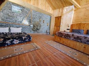 a room with a bed and a stone wall at The Cedar Nook Tree House in Jibhi