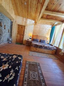 a large room with two beds and a rug at The Cedar Nook Tree House in Jibhi