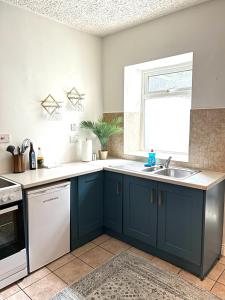 a kitchen with blue cabinets and a sink at Quiet townhouse in Cork in Cork