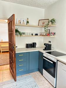 a kitchen with blue cabinets and an open door at Quiet townhouse in Cork in Cork