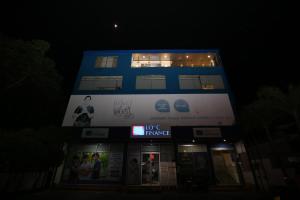 un bâtiment bleu avec un panneau sur lui la nuit dans l'établissement Ideal Residence, à Matara