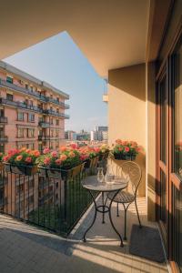 a table and chairs on a balcony with flowers at Residenze Italia in Sesto San Giovanni