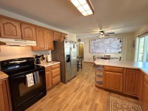 a kitchen with wooden cabinets and a black refrigerator at North Country Retreat in Saint Ignace