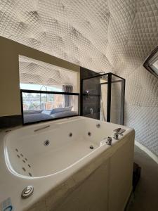 a large white tub in a bathroom with a mirror at Luahara Glamping Domo Experience La Primavera - Presa de las Tortugas in Orendain +92 photos
