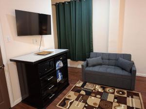 Una sala de estar con un sofá y un televisor en Rey'z Hotel and Suites, en Vreed en Hoop 5 fotos más