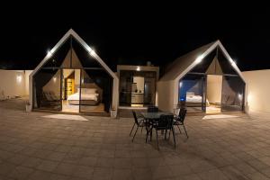 a patio with a table and chairs at night at ستاي إن Stay Inn in Ma‘mad