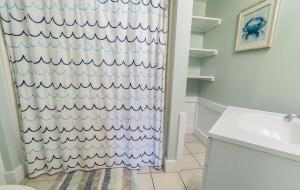 une salle de bain avec un rideau de douche et un lavabo dans l'établissement Changes In Latitude home, à Holden Beach