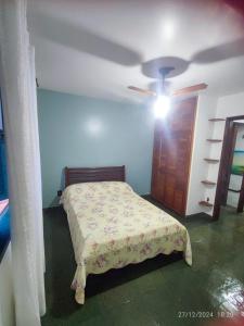 a bedroom with a bed and a ceiling fan at Triplex na Prainha in Arraial do Cabo