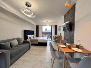 a living room with a couch and a table at Go-Gudauri The Atrium Residence in Gudauri