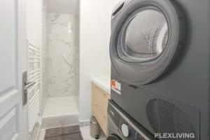 Eine Waschmaschine, die auf einer Kommode im Badezimmer steht in der Unterkunft Modern room in spacious T7 in Paris 20 in Paris