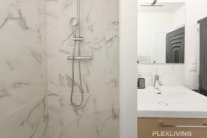 ein Badezimmer mit Dusche und Waschbecken in der Unterkunft Modern room in spacious T7 in Paris 20 in Paris