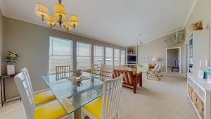 a dining room and living room with a glass table and chairs at Sun and Moon in Port Bolivar