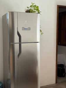 a stainless steel refrigerator with a plant on top of it at Vila Kairós in Caraíva