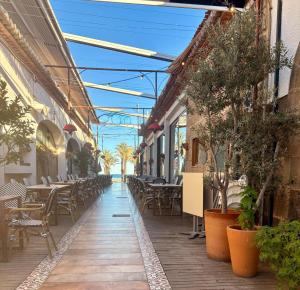 an outdoor patio with tables and chairs and plants at Nook arenal Jávea in Platja de l'Arenal