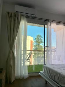 a bedroom with a bed and a large window at Nook arenal Jávea in Platja de l'Arenal