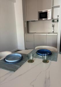 two blue plates sitting on a table in a kitchen at Nook arenal Jávea in Platja de l'Arenal +2 photos
