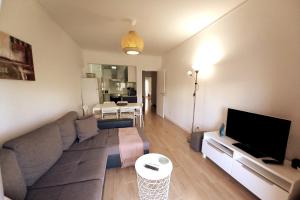 Una sala de estar con un sofá y un televisor de pantalla plana. en Abertura Mar Zen, en Cavacos