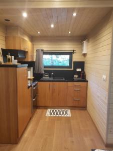 a kitchen with wooden cabinets and a sink and a window at Lodge Slow Life - Mas de Rey in Arpaillargues-et-Aureillac
