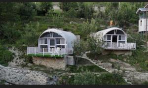 Dos casas con puertas blancas en una colina en The Lush Pods, en Jāmb