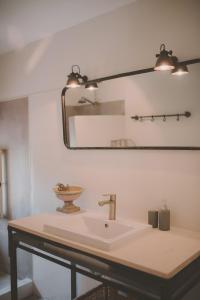 een badkamer met een wastafel en een spiegel bij Van Gogh - Mas De Rey in Arpaillargues-et-Aureillac