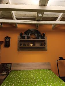 Schlafzimmer mit orangefarbenen Wänden und einem grünen Bett in der Unterkunft Dahai Ferienwohnung Seebad Warnemünde Schulstraße 1, OG in Rostock