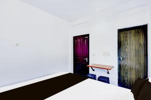 a bedroom with a bed and a desk and a door at Hotel O A Star Lodge in Trichūr