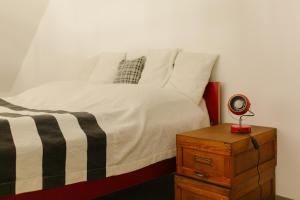 a bedroom with a bed and a night stand with a clock at LOFT Köveskál in Köveskál