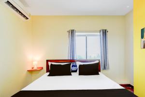 Un dormitorio con una cama grande con ventana. en Hotel O SRINIVASA RESIDENCY, en Pedda Ambarpet 21 fotos más