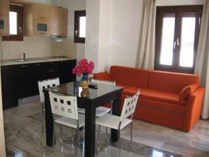 salon z kanapą, stołem i krzesłami w obiekcie Topaz Apartments w mieście Kokkari