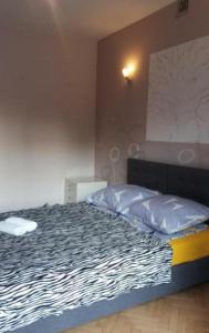 Un dormitorio con una cama con un edredón blanco y negro. en B&b flats, en Wroclaw